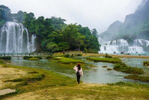 woman standing in front of the Ban Gioc Waterfall in Cao Bang province