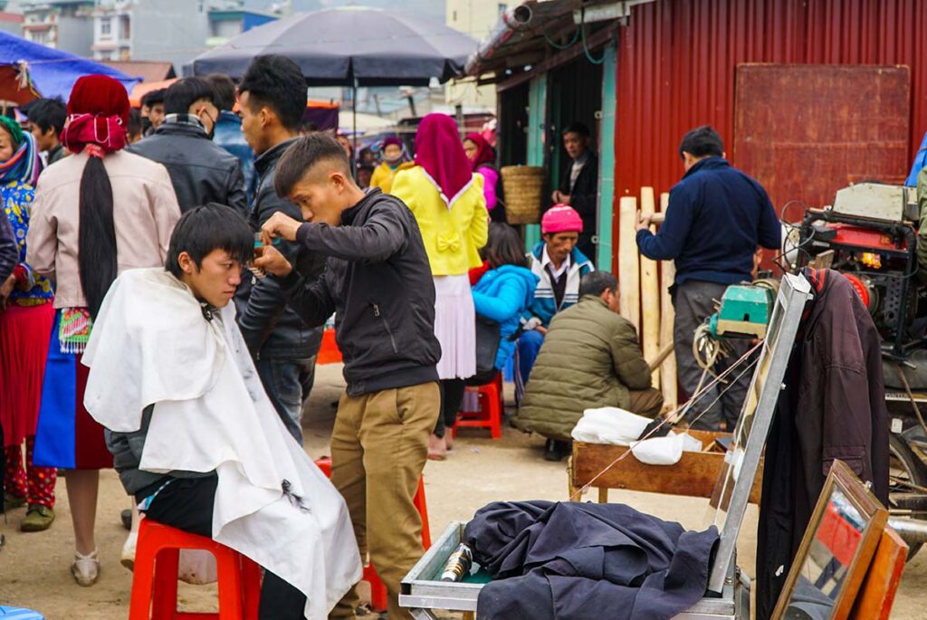ethnic minority man get his hair cut on the Dong Van Market