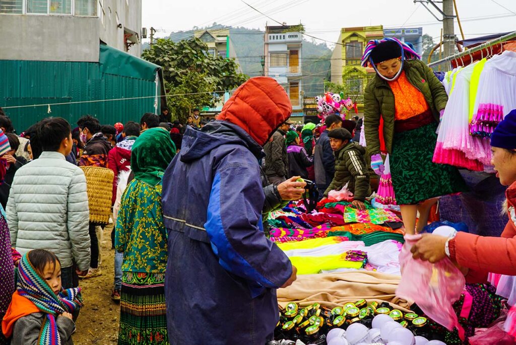 ethnic minority people shopping for clothes at Dong Van Market