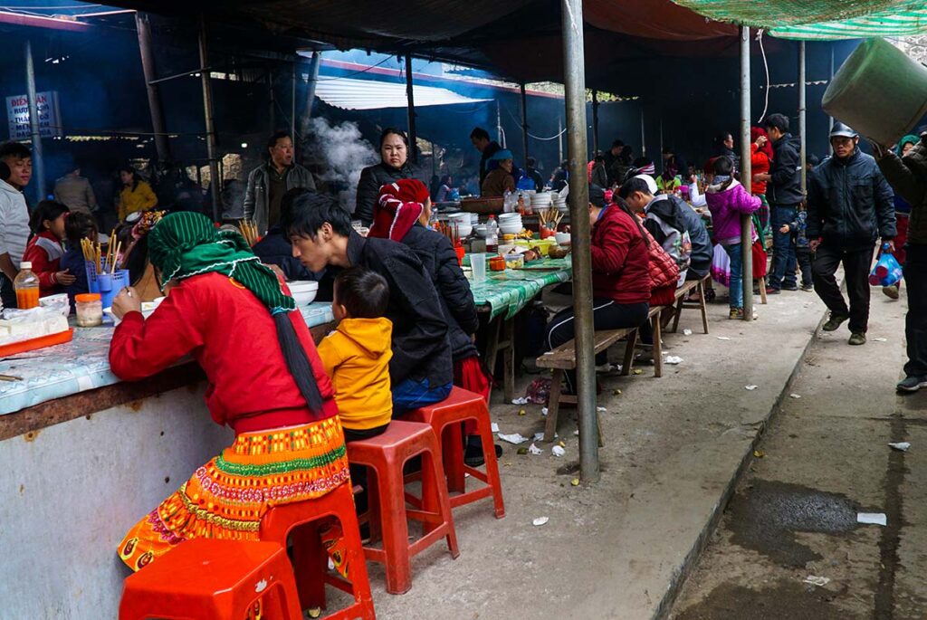 ethnic people eating local food at the Dong Van Market