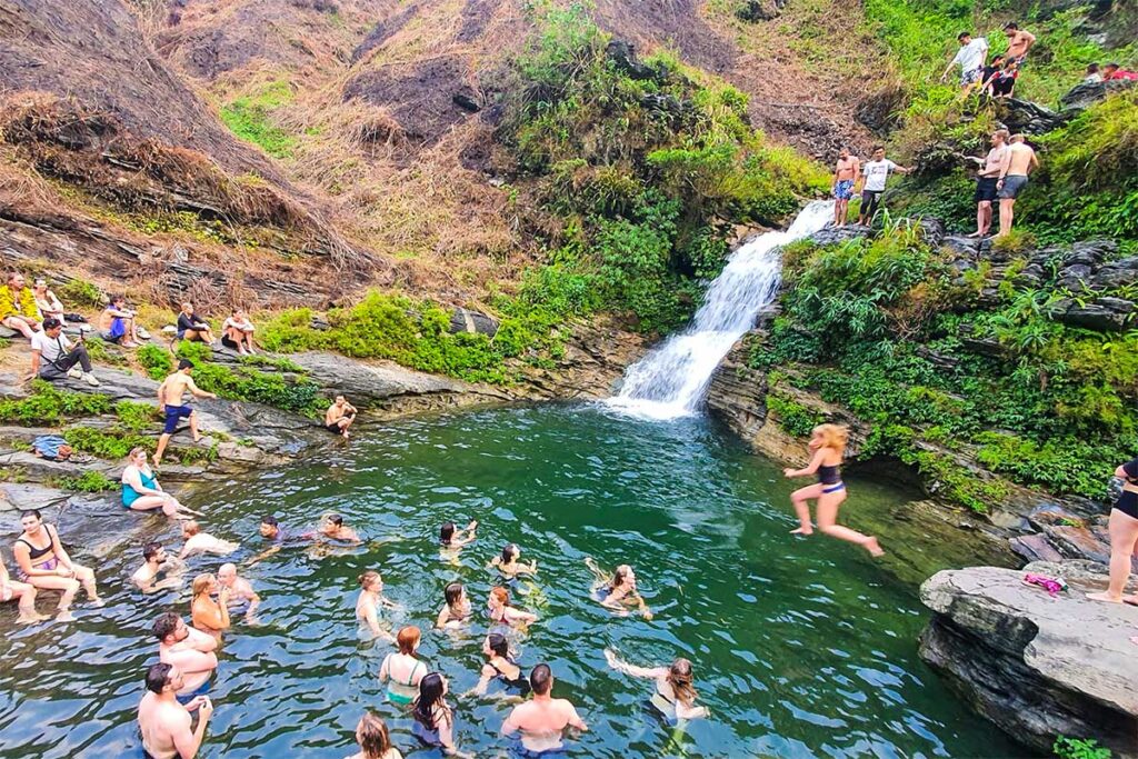 Mange mennesker svømmer ved Du Gia-vandfaldet